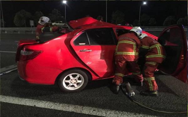 Anggota bomba berusaha mengeluarkan mangsa yang tersepit dalam kejadian di Kilometer 268 Lebuh Raya Utara-Selatan, arah utara, berhampiran susur keluar Tol Ainsdale, Seremban pada awal pagi Isnin. - Foto ihsan JBPM
