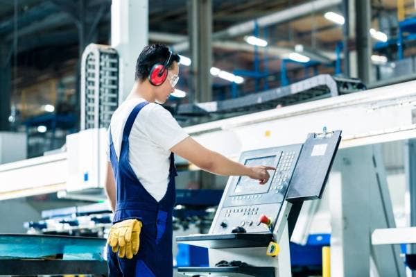 A worker entering data in a CNC machine at factory floor to get the production going. (Sinar file pix)