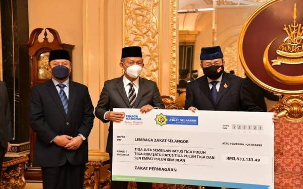 Sultan Sharafuddin (kanan) menerima bayaran zakat perniagaan daripada TNB diserahkan oleh Hassan (tengah) pada Isnin.
