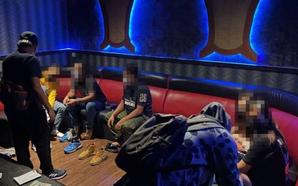 Warga asing yang ditahan dalam serbuan di sebuah pusat hiburan di Pasir Gudang di sini pada Ahad.