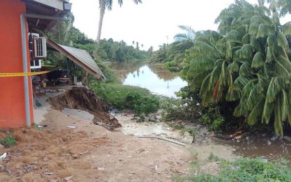 Keadaan bahagian belakang salah sebuah rumah yang terletak berdekatan tebing sungai yang runtuh di Kampung Kubang Kuau, Repek, Bachok. Foto Sinar Harian