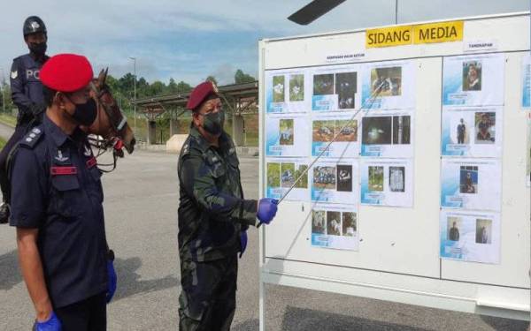 Azhar (kanan) menerangkan 15 kejayaan yang berjaya dicatatkan oleh pada Op Benteng Kawalan Sempadan Darat Malaysia - Thailand di Bukit Kayu Hitam pada Selasa. Turut kelihatan Rosman (kiri).