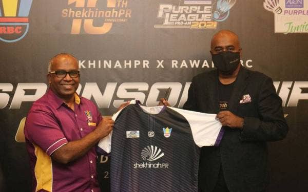 Jeyaseelan (kiri) menyerahkan jersi baharu pasukan Rawang BC kepada Christopher pada Majlis Penyerahan Tajaan ShekhinahPR di Kelab Taman DiRaja Perdana pada Selasa.