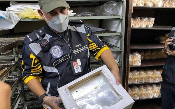 Mohd Wazir menunjukkan najis tikus yang ditemui pada plastik bungkusan roti.