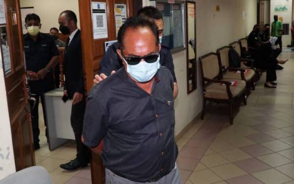 Tertuduh dibawa keluar dari mahkamah selepas dijatuhkan hukuman denda RM100,000 atas pertuduhan menerima suapan.