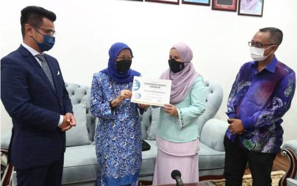 Nik Maheran (dua dari kanan) dan Asiah menunjukkan sijil pengiktirafan sebagai Universiti Keusahawanan di Kampus UMK Bachok. - Foto Media UMK