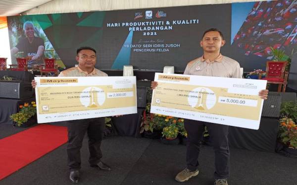 Amiruddin (kanan) dan Mohd Fiqrul Amerullah antara penerima anugerah sempena Hari Produktiviti dan Kualiti Perladangan 2021 di Kilang Sawit FGV Moakil, Segamat pada Khamis.
