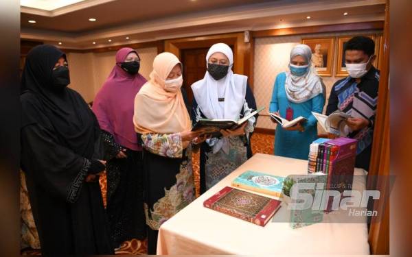 Nor Sham (tiga dari kanan) bersama Normah Hanum melihat sumbangan al-Quran oleh WUIF di Pejabat Setiausaha Kerajaan Negeri Perak di Ipoh pada Khamis.
