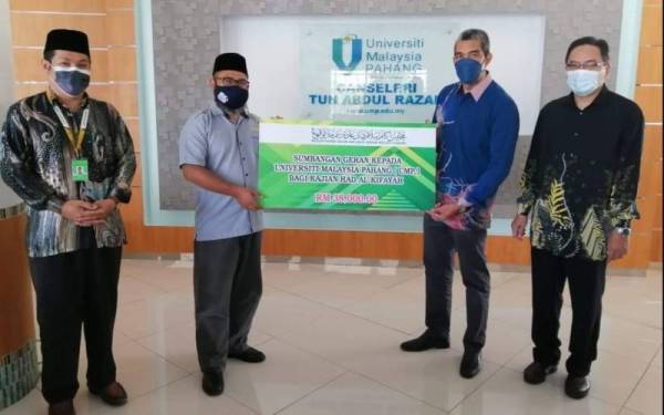 Gimik penyerahan sumbangan telah disampaikan oleh Asmadi (dua dari kiri) kepada Pengarah Pusat Islam dan Pembangunan Insan UMP, Prof Madya Dr Rashidi Abbas (dua dari kanan) di Kompleks UMP.