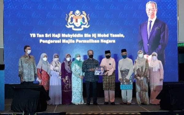 Muhyiddin (lima dari kanan) ketika pelancaran buku biografi bergambar 'Abah Teguh Kita Bersama' di Hotel InterContinental di Kuala Lumpur pada Jumaat.