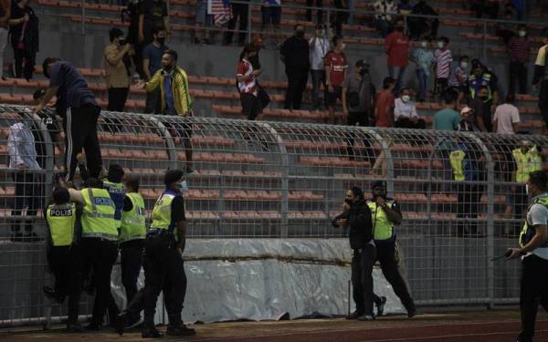 IMBAS KEMBALI...Anggota polis menahan penyokong Kuala Lumpur City FC yang merempuh masuk ke padang ketika meraikan kemenangan selepas menewaskan Selangor FC di suku akhir kedua Piala Malaysia di Cheras pada 18 November lalu. - Foto fail Bernama