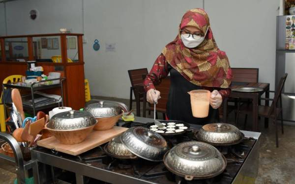 Noryati menyediakan kuih bekang semasa ditemui di premisnya di Kuala Ibai. - Foto Bernama