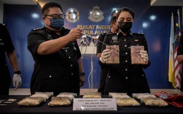 Mustafa (kiri) bersama pegawainya menunjukkan dadah jenis heroin base, heroin dan syabu yang dirampas ketika mengadakan sidang media di Ibu Pejabat Polis Kontinjen Pulau Pinang pada Sabtu. - Foto Bernama