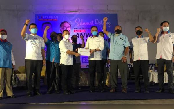 Anwar (empat dari kanan) menerima borang keahlian Maszlee ( tiga dari kiri) di Dewan Kampung Baru Machap di sini pada Sabtu.