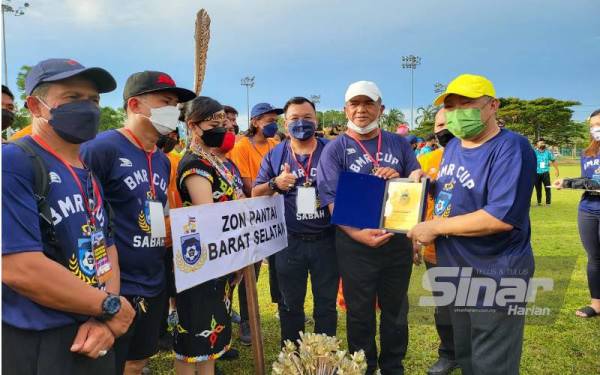 Bung Moktar menyampaikan sijil penghargaan kepada pasukan bola sepak sempena perasmian Piala Datuk Seri Bung Moktar Radin di Kompleks Sukan Likas, Kota Kinabalu.