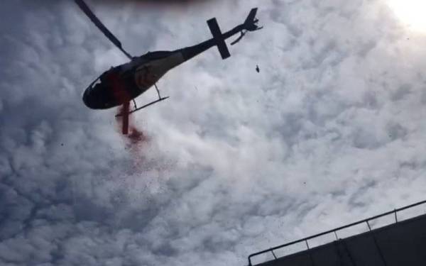 Sebuah penyelidikan helikopter terbang rendah menyertai prosesi pemakaman