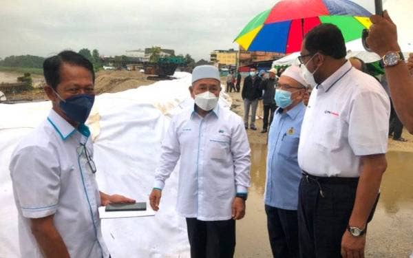 Tuan Ibrahim (dua dari kiri) bersama Hanifa (dua dari kanan) serta Kamal (kiri) melihat Projek Penstabilan Tebing Sungai Kelantan di Kampung Pohon Celagi, Pasir Mas pada Ahad.