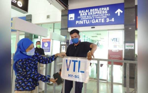 Petugas melakukan persiapan untuk pelaksanaan VTL yang akan bermula pada Isnin di Terminal Bas dan Pengangkutan Awam Larkin Sentral, Larkin, Johor Bahru pada Ahad.