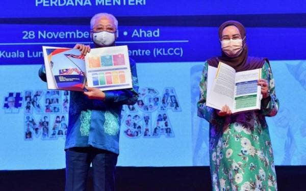 Perdana Menteri Datuk Seri Ismail Sabri Yaakob (kiri) menunjukkan buku Pelan Tindakan Perpaduan Negara 2021-2030 dan Kami @ Pelan Perpaduan Keluarga Malaysia 2021-2025 ketika Majlis Pelancaran di Pusat Konvensyen Kuala Lumpur hari ini. - Foto Bernama