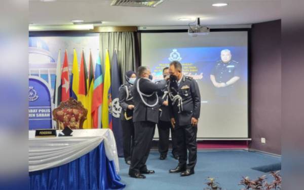 Idris menyempurnakan sesi pemakaian lencana pangkat kepada Jauteh dalam majlis serah terima tugas Timbalan Pesuruhjaya Polis Sabah di IPK Kota Kinabalu.