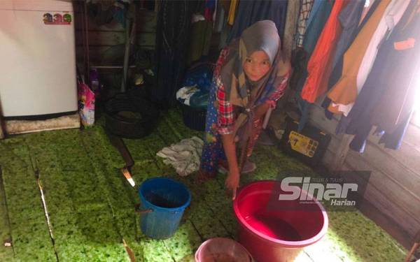 Atap bocor menyebabkan Mazita Hassan Pakry, 50, terpaksa menyediakan bekas untuk menadah air yang masuk ke dalam rumahnya. - FOTO SINAR HARIAN