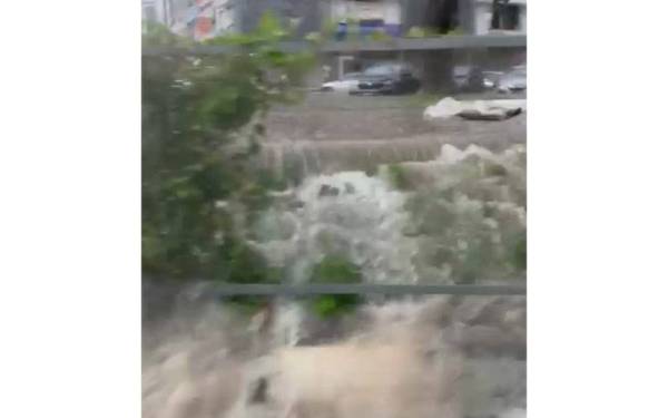 Tangkap layar video tular mengenai limpahan air deras di kawasan perparitan berdekatan pusat komersial di Bandar Puchong Jaya.
