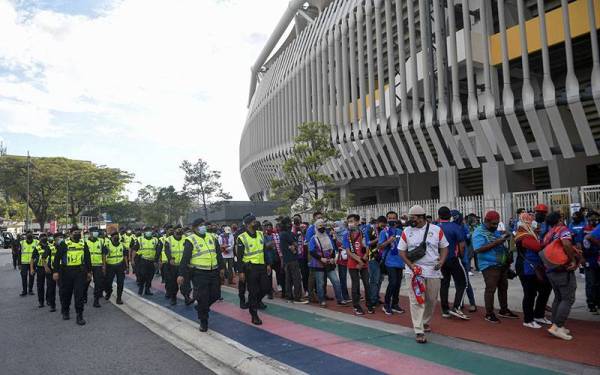 Pasukan polis mengawal keadaan para penyokong bola sepak yang berkumpul di sekitar pekarangan Stadium Nasional Bukit Jalil bagi menyaksikan Perlawanan Akhir Piala Malaysia 2021 Johor Darul Ta’zim (JDT) menentang Kuala Lumpur City FC (KL City) malam ini.