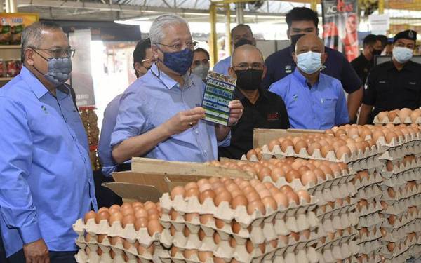Perdana Menteri Datuk Seri Ismail Sabri Yaakob (dua, kiri) menunjukkan harga telur semasa melakukan tinjaun harga barang di MyFarm Outlet Kasih Putrajaya hari ini.