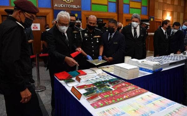 Hamzah (dua dari kiri) melawat ruang pameran pada Majlis Sambutan Hari Imigresen 2021 di Auditorium Kompleks D pada Rabu. - Bernama 