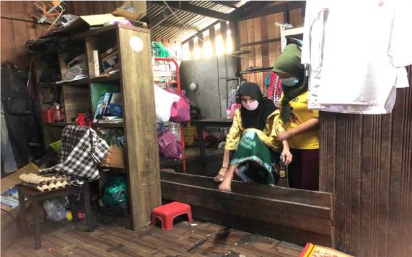 Siti Aishah (kanan) membantu ibunya, Che Mas yang buta sejak 27 tahun lalu.