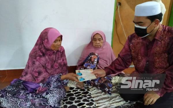 Ahmad Fadzli menyampaikan sumbangan khairat kematian kepada Latipah di Kampung Matang Bagan, Sungai Petani pada Khamis.