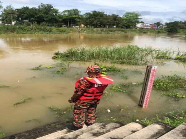 Anggota dari Balai Bomba dan Penyelamat Rantau Panjang sedang melalukan tinjauan di Sungai Golok yang kini sudah mencecah paras amaran 8.31 meter.
