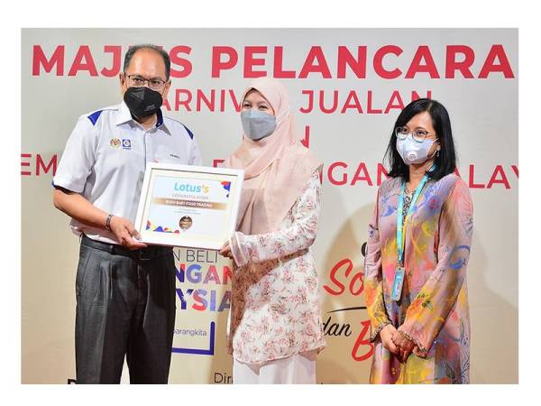 Hasnol (kiri) ketika menyampaikan sijil kepada syarikat PKS yang terpilih sebagai pembekal Lotus’Malaysia sambil disaksikan Azliza ketika program Pelancaran KBBM Lotus’s Malaysia di Lotus’s Ampang, di sini, pada Khamis.