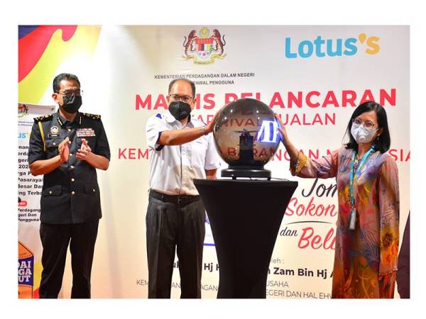 Hasnol (tengah) ketika menyempurnakan program Pelancaran KBBM Lotus’s Malaysia bersama Azliza (kanan) di Lotus’s Ampang, Kuala Lumpur pada Khamis.