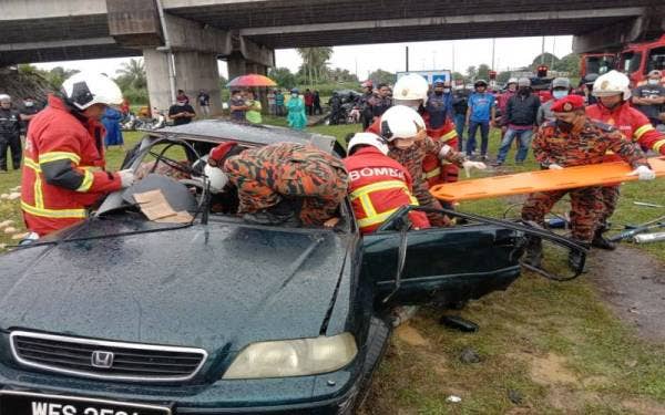Anggota bomba bertungkus lumus mengeluarkan mangsa yang tersepit di bahagian pemandu yang terlibat dalam kemalangan Jalan Kampung Kubang Jela, Manir, Terengganu. (foto: ihsan BBP Kuala Terengganu)