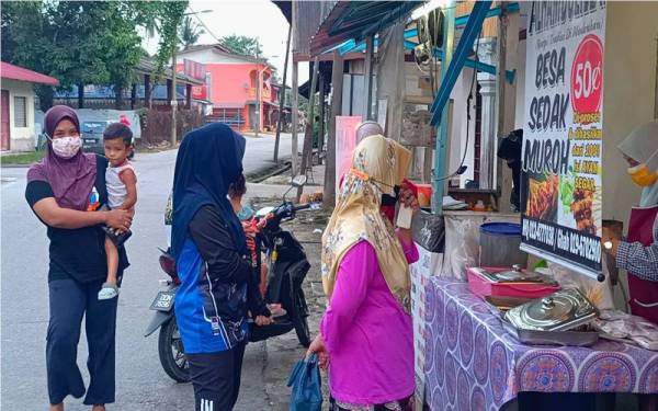 Pelanggan menunggu giliran mendapatkan sate di gerai Siti Rajihah di Pekan Tok Uban, Pasir Mas.