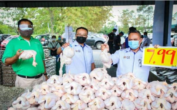 Mohd Hairul Anuar (kanan) dan Mas Imran (kiri) menunjukkan minyak masak yang dijual pada harga murah dalam PJKM Peringkat Negeri Johor di Pasaraya Econsave Taman Daya, Johor Bahru, pada Sabtu.