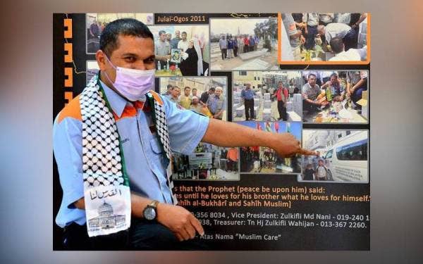 Zulkifli menunjukkan aktiviti-aktiviti yang pernah dilakukan Muslim Care Malaysia Society dalam membantu warga Palestin. - Foto fail Sinar Harian