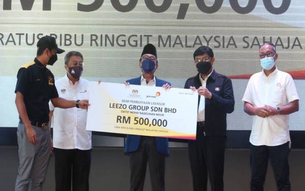 Zakaria (tengah) bersama Mohd Izhar (dua dari kanan) ketika menyampaikan dana pembiayaan Skim Lisensor kepada Syarikat Leezo Group Sdn Bhd di sini pada Sabtu.