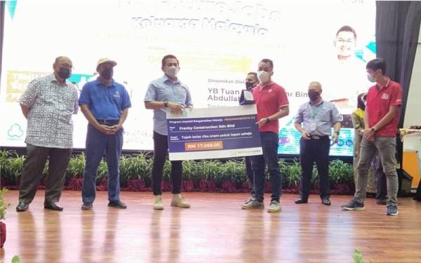 Mohd Shahar (tiga dari kiri) menyampaikan cek kepada wakil syarikat yang menyertai Program Inisiatif Pengambilan Pekerja Penjana Kerjaya 3.0 pada Majlis Perasmian Karnival Kerjaya MyFutureJobs Keluarga Malaysia di Paya Besar, Kuantan pada Sabtu.