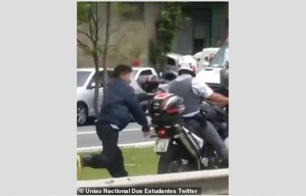 Seorang lelaķi disyaki pengedar dadah digari pada sebuah motosikal polis di Sao Paolo baru-baru ini. - Foto Twitter/Uniao Nactional Dos Estudantes