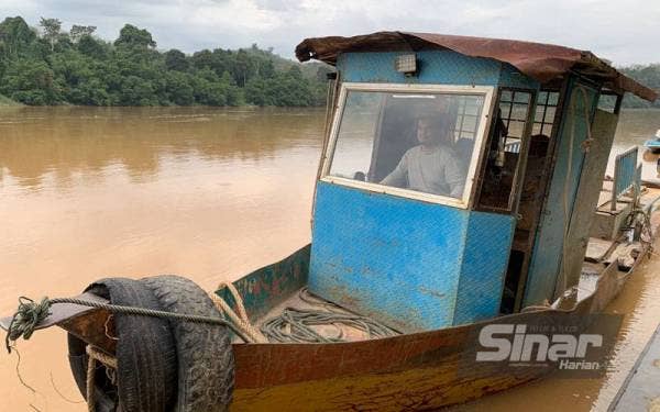 Amirul mengemudi bot kecil selepas perkhidmatan feri milik Koperasi Kampung Pasir Kelang Berhad yang membawa kereta menyeberangi Sungai Kelantan di Kuala Krai dihentikan sementara.