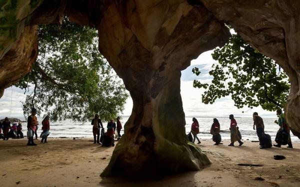Sekumpulan peserta melalui gerbang laut pada Program Plogging Batik di kawasan Geotapak Chimney Trail Tanjung Kubong hari ini.