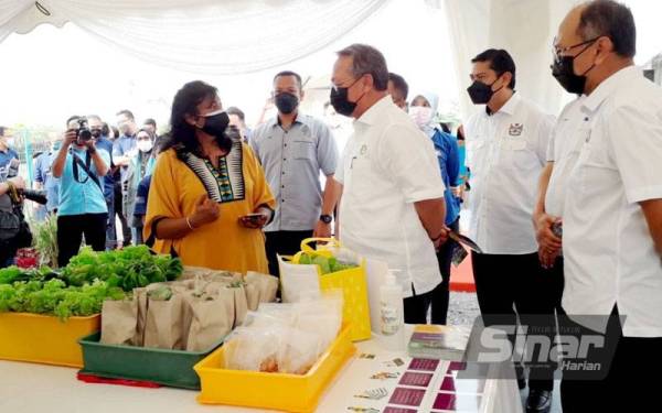 Hasni (tengah) diberi penerangan semasa melawat tapak pameran ketika Majlis Pelancaran Kebun Bandar di Johor Bahru pada Ahad.