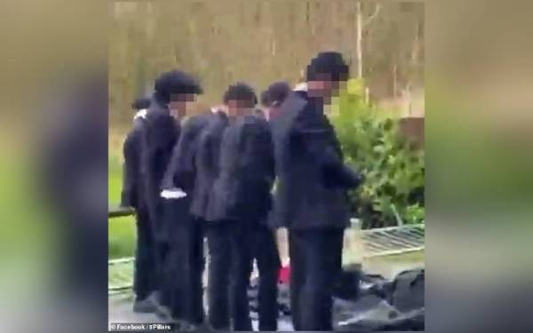 Sekumpulan pelajar bersolat secara berjemaah di luar bangunan Oldham Academy North, bandar Oldham baru-baru ini. - Foto Facebook/ 5Pillars