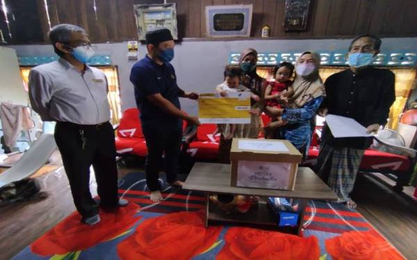 Nor Shahida menerima replika cek sebagai bantuan Faedah Pengurusan Mayat (FPM) RM2,000 daripada Perkeso yang disampaikan Abdul Yunus.