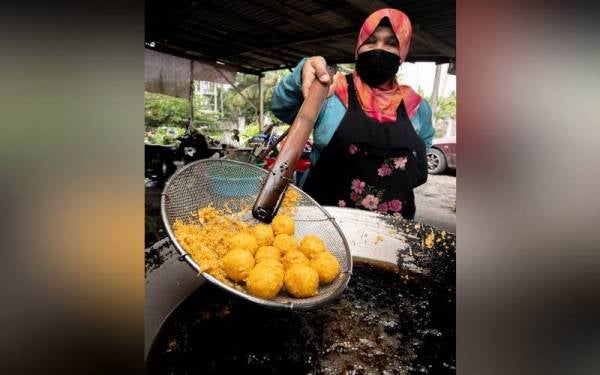 Peniaga ubi getuk, Rakiah Mamat, 50, menggoreng ubi getuk ketika ditemui Bernama di gerainya di Kampung Jambu Merah Melor. - Foto Bernama
