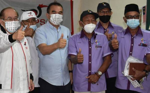 Douglas (kiri) dan Ahli Parlimen Betong, Datuk Robert Lawson Chuat (tiga dari kiri) merakam gambar kenangan selepas mengadakan pertemuan dengan ahli Persatuan Pesara Kerajaan Spaoh di Spaoh, Betong pada Selasa.