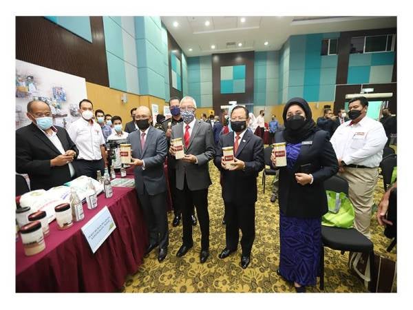 Ronald (kiri) bersama Pengerusi Ahli Jemaah Pengarah NAFAS, Zamri (dua dari kiri) memegang sampel beras hasil tanaman padi projek bersepadu di Kg Namdam, Kedah pada Majlis Pra Pelancaran Kad Pintar Keluarga Peladang (Peladang-i).