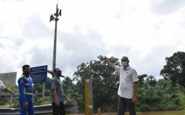  Timbalan Pengarah Pembangunan Jabatan Pengairan dan Saliran (JPS) Terengganu Osman Abdullah (kanan) menunjukkan lokasi stesen siren amaran awal banjir semasa melakukan lawatan ke stesen pemantauan banjir bagi menghadapi fenomena Monsun Timur Laut di Kampung Pengkalan Ajal, Hulu Teregganu hari ini. - Foto Bernama